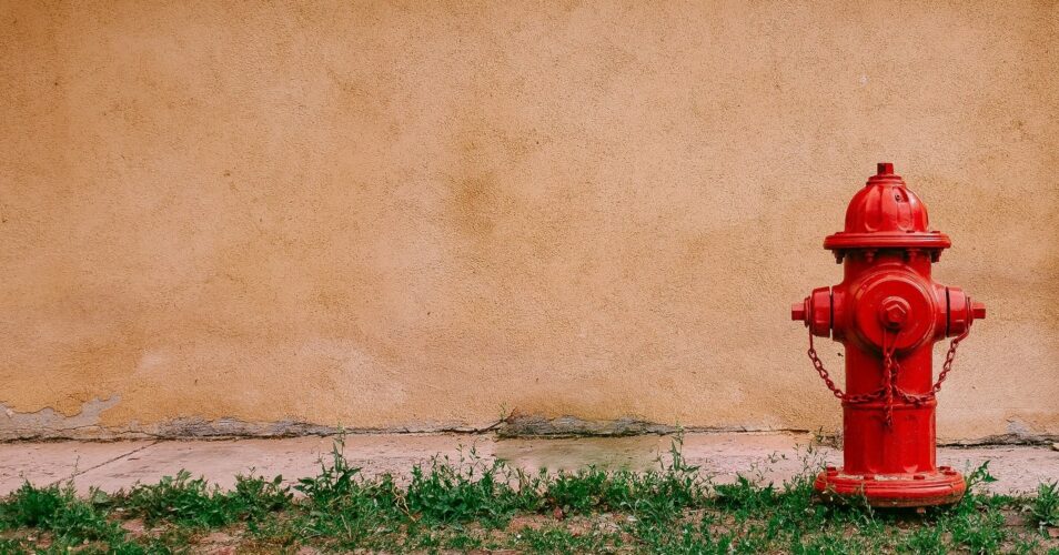 fire hydrant in front of orange wall